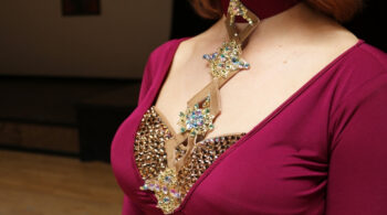 closup of neckline applique on burgundy latin dress