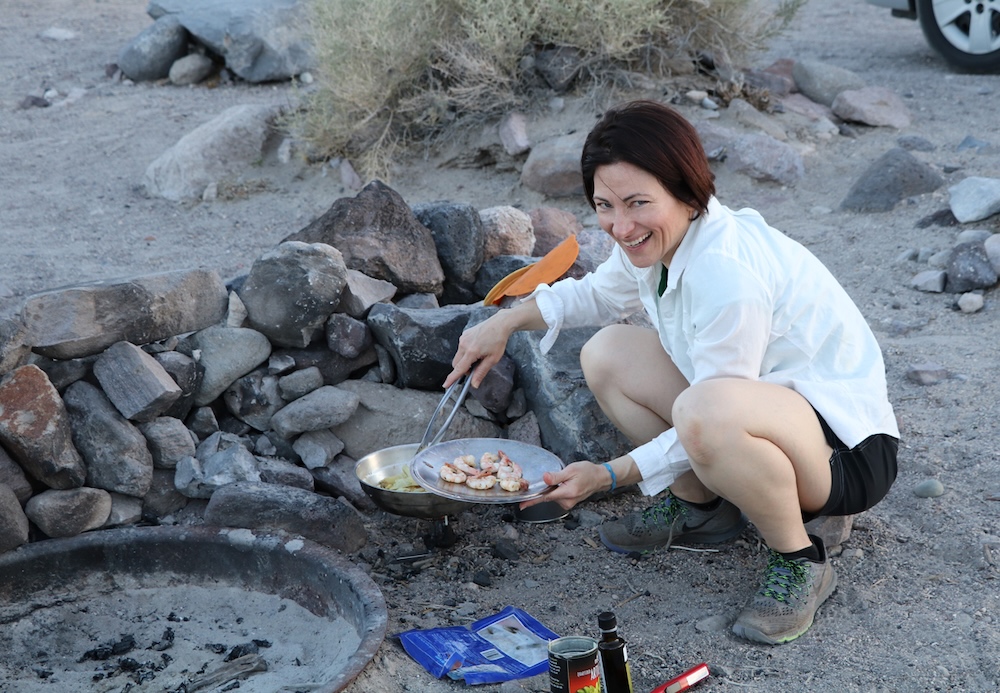 Teresa Sigmon, cooks shrimp dinner over a burner while camping in Death Valley, California